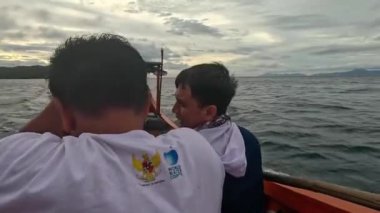 Aceh, Endonezya - 24 Temmuz 2024: Balıkçılar kötü hava şartları nedeniyle balıkçılığı iptal ettiler. Fırtına ve büyük dalgalar sırasında hareket eden tekneden deniz pelerini. Balık ve balıkçılık kavramı.