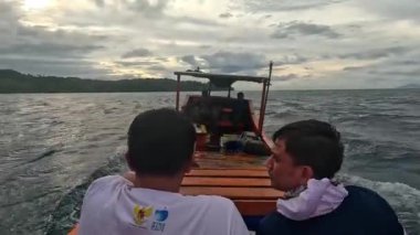 Aceh, Endonezya - 24 Temmuz 2024: Balıkçılar kötü hava şartları nedeniyle balıkçılığı iptal ettiler. Fırtına ve büyük dalgalar sırasında hareket eden tekneden deniz pelerini. Balık ve balıkçılık kavramı.