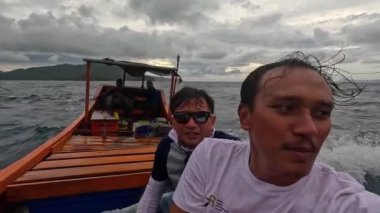 Aceh, Endonezya - 24 Temmuz 2024: Balıkçılar kötü hava şartları nedeniyle balıkçılığı iptal ettiler. Fırtına ve büyük dalgalar sırasında hareket eden tekneden deniz pelerini. Balık ve balıkçılık konsepti. Yavaş Hareket Görüntüsü.