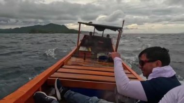 Aceh, Endonezya - 24 Temmuz 2024: Balıkçılar kötü hava şartları nedeniyle balıkçılığı iptal ettiler. Fırtına ve büyük dalgalar sırasında hareket eden tekneden deniz pelerini. Balık ve balıkçılık konsepti. Yavaş Hareket Görüntüsü.