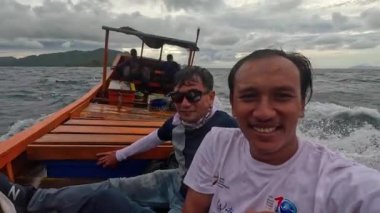 Aceh, Endonezya - 24 Temmuz 2024: Balıkçılar kötü hava şartları nedeniyle balıkçılığı iptal ettiler. Fırtına ve büyük dalgalar sırasında hareket eden tekneden deniz pelerini. Balık ve balıkçılık konsepti. Yavaş Hareket Görüntüsü.