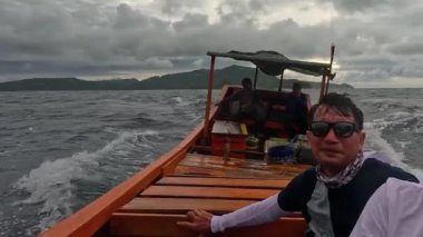 Aceh, Endonezya - 24 Temmuz 2024: Balıkçılar kötü hava şartları nedeniyle balıkçılığı iptal ettiler. Fırtına ve büyük dalgalar sırasında hareket eden tekneden deniz pelerini. Balık ve balıkçılık konsepti. Yavaş Hareket Görüntüsü.