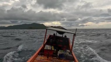 Aceh, Endonezya - 24 Temmuz 2024: Balıkçılar kötü hava şartları nedeniyle balıkçılığı iptal ettiler. Fırtına ve büyük dalgalar sırasında hareket eden tekneden deniz pelerini. Balık ve balıkçılık kavramı.