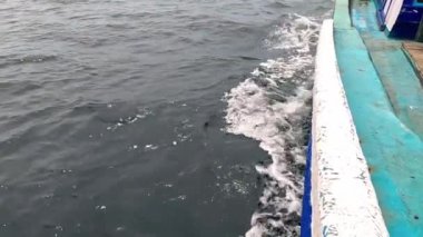 Tekne denizin yüzeyinde acele eder. Denizde hareket halindeki teknenin yan görüntüsü. Okyanus gezisi. Su nakli. Yavaş Hareket Görüntüsü.