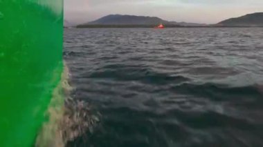 Tekne denizin yüzeyinde acele eder. Denizde hareket halindeki teknenin yan görüntüsü. Okyanus gezisi. Su taşımacılığı.