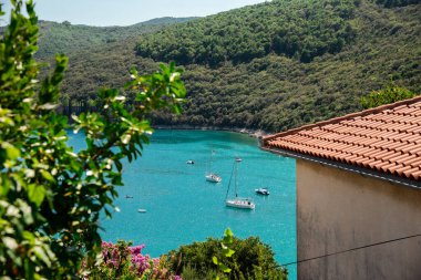 Crotia sahilinde güzel bir deniz manzarası, bir körfez ve dağlarda küçük bir tekne.