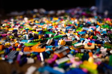 Renkli plastik oyuncaklar, yerde tuğlalar.