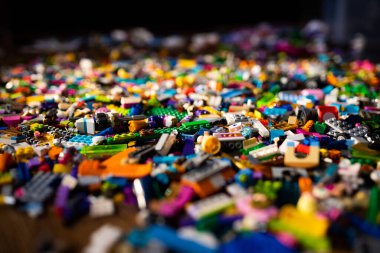 Renkli plastik oyuncaklar, yerde tuğlalar.