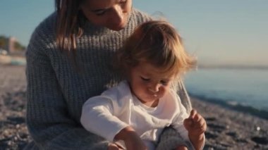 Mutlu beyaz bir aile gün batımında kumsalda oynayıp eğleniyor. Ağır çekim. Aile, Özgürlük ve Seyahat konsepti. Yüksek kalite 4k görüntü
