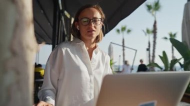Ciddi, güzel, genç bir kadın, kafeteryada dizüstü bilgisayarla oturmuş internette internet üzerinden iletişim teknolojisi yazarak ağır çekimde iş yapıyor. Yüksek kalite 4k görüntü