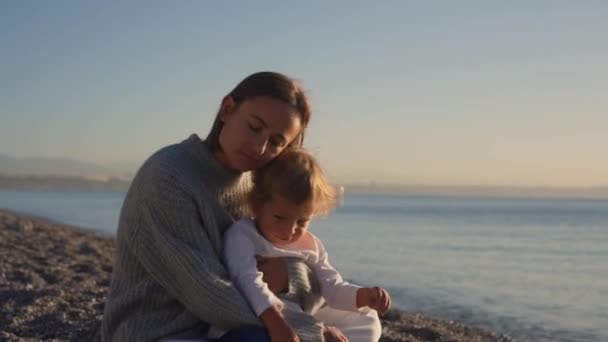 馬で赤ちゃんと遊ぶ 美しい日の出 女性は海の上に輝く小さな子供 親の愛 太陽を受け入れる 高品質4K映像 — ストック動画