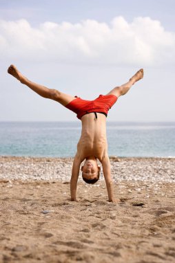 Çocuk plajda akrobasi yapıyor. Yüksek kalite fotoğraf
