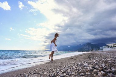 Sahilde koşan mutlu genç bir kızın arka görüntüsü. Yüksek kalite fotoğraf