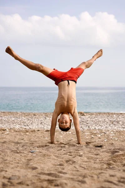 Dzieciak Robi Akrobacje Plaży Wysokiej Jakości Zdjęcie — Zdjęcie stockowe