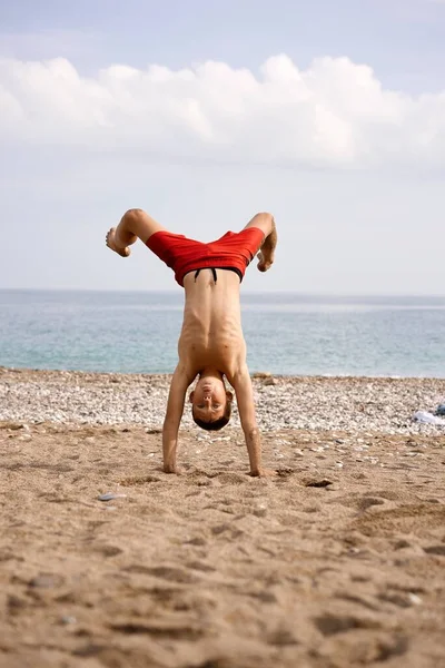 Dzieciak Robi Akrobacje Plaży Wysokiej Jakości Zdjęcie — Zdjęcie stockowe