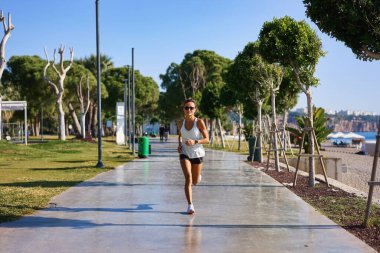 4K plajında koşan bir kadın. Sabah Türkiye 'de plaj yakınında koşan beyaz kadın..
