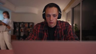 Yorgun, sinirli, stresli baba evden uzakta çalışıyor. Anne ve çocuklar gürültülü bir şekilde oynarlar. Tecrit sırasındaki aile. Yüksek kalite 4k görüntü