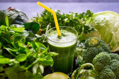 Gri ahşap masada taze ıspanaklı sağlıklı yeşil smoothie kavanozları, yakın plan. Detoks diyet kavramı: Ahşap masada yeşil sebzeler