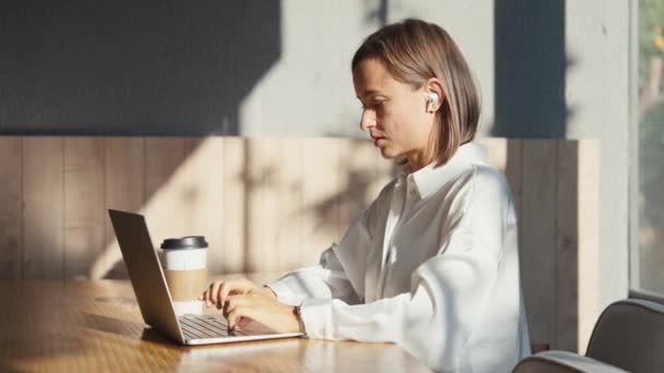 累了的女人在电脑前工作了很长时间 坐着不动 腰酸背痛很厉害 年轻女性在办公室里用笔记本电脑的时候感到头痛脚痛 — 图库视频影像