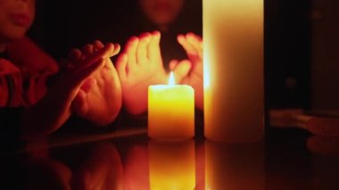Kesinti sırasında mumların yanında oturan bir aile. Ukrayna 'da Savaş.