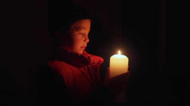 在乌克兰的一场停电中 男孩在家里 在一片漆黑中举着蜡烛 — 图库视频影像