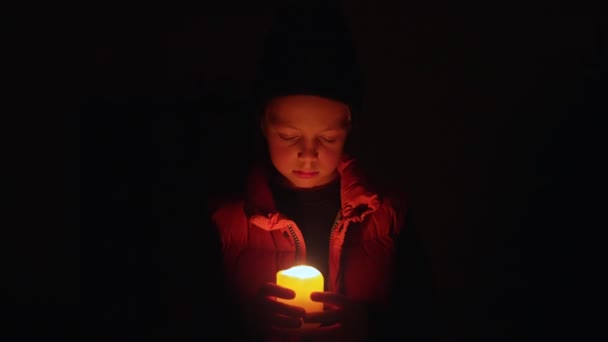 在乌克兰的一场停电中 男孩在家里 在一片漆黑中举着蜡烛 — 图库视频影像
