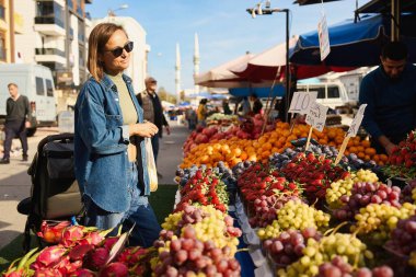 ANTALYA, TURKEY - 3 Eylül 2022. Çiftçi pazarından sebze ve meyve alan genç bir kadın.