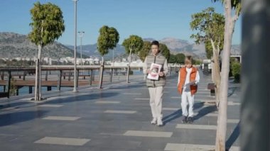 İki kardeş kayıp bir evcil hayvanı arıyor, posterler asıyorlar.