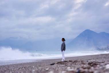 genç kadın kum plaj ve deniz dalgaları izlerken