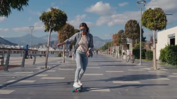 若いスタイリッシュな10代の女の子はスケートボードに乗ることを学ぶ 流行の女の子は初めてスケートボードに乗るしようとします 高品質4K映像 — ストック動画