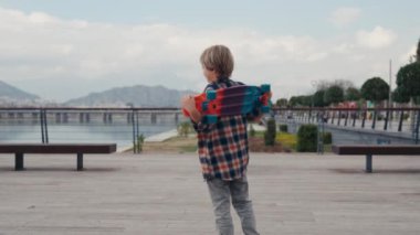 Portrait of boy holding skateboard. Boy with skateboard outdoor