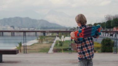 Portrait of boy holding skateboard. Boy with skateboard outdoor