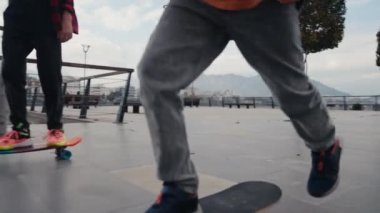 Happy boys riding on skateboard at the riverside