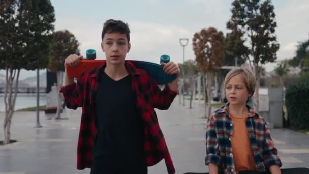 郊外の通りにスケートボードを持っている男の子 — ストック動画