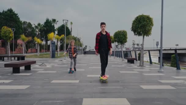 川沿いのスケートボードに乗って幸せな男の子 — ストック動画
