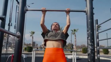 Woman doing pull-up. Strong girl in sportswear doing pull up exercise. Be H3althy