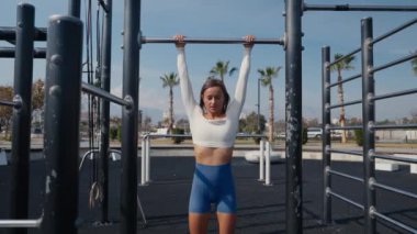 Woman doing pull-up. Strong girl in sportswear doing pull up exercise. Be H3althy