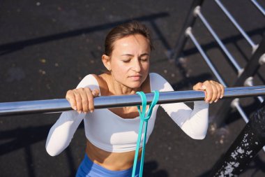 Woman doing pull-up. Strong girl in sportswear doing pull up exercise. Be H3althy