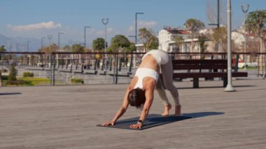 Pretty woman doing yoga exercises in the park Practicing of yoga outdoors. Be H3althy