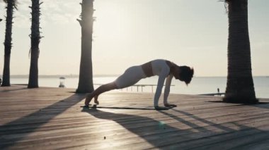 Dışarıda yoga yapan genç bir kadın spor egzersizleri ve sağlıklı bir yaşam tarzı için refah konsepti. Yüksek kalite 4k görüntü