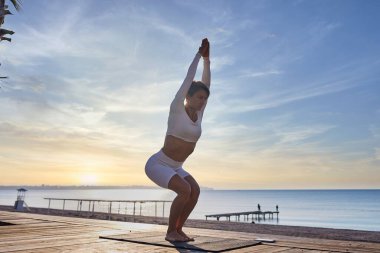 Spor Ortaçağ Kadın Açık havada Yoga Yapıyor, Aktif Giyimde Atletik Kadın Giyimi Denize Yakındaki Ahşap İskele 'de Egzersiz Yapıyor. Yüksek kalite fotoğraf