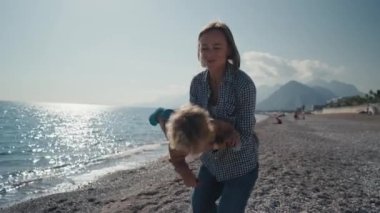 Kafkasyalı anne, güneşli bir günde küçük şirin oğlu plajında oynuyor. Gülümseyen anne ve güzel çocuk deniz kenarında rahatlayıp birlikte eğleniyorlar. Genç anne tatil sırasında deniz kenarında yeni doğan bebek kumsalında gün batımını oynuyor.. 