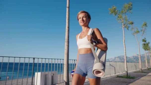Athlete Girl Walking Seacoast Twilight Holding Sport Mat Yoga Woman — ストック動画
