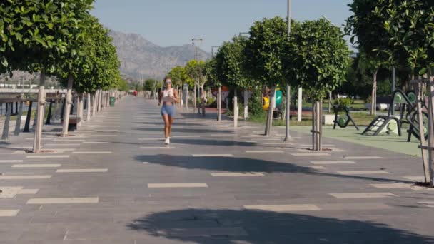 Güneşli Aydınlık Bir Günde Şehir Parkında Koşan Beyaz Bir Kadın — Stok video