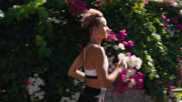 スポーティなセクシーな女性ランニング 日の出に屋外で運動 サンレンズフレア 健康的なアクティブライフスタイル バックビュー 高品質の4K映像 — ストック動画