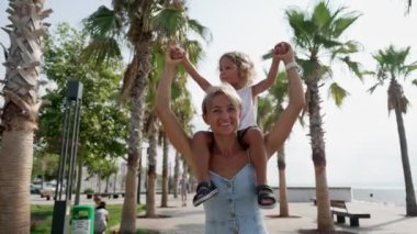 Küçük oğlu modern yel değirmenleriyle tarlada oturan genç anneye bakın. Mutlu bir aile. Çocuğun kollarını yana doğru uzattığı ve doğada birlikte yürüdükleri bir aile.