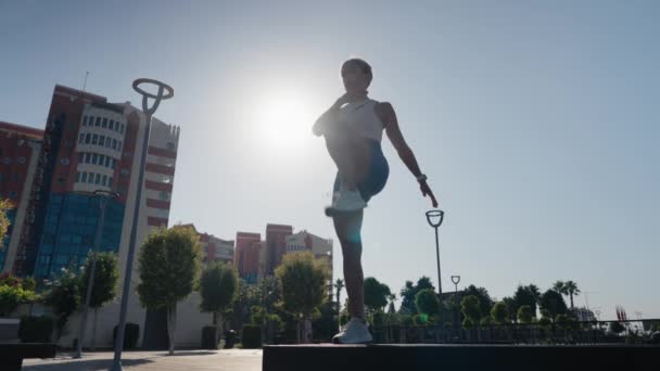 Güzel Sportif Bir Kız Tahta Bir Bankta Uzanarak Bacak Esnetiyor — Stok video