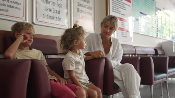 Dzieci Matka Siedzą Szpitalnym Korytarzu Ubrani Zwykłe Ubrania Czekają Czas — Wideo stockowe