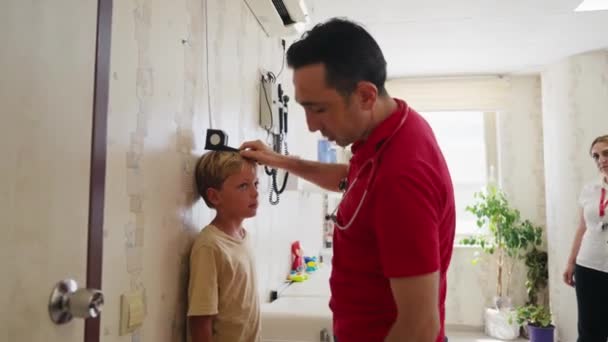 Lekarz Pediatra Badający Dziecko Mężczyzna Lekarz Badania Chłopcy Ucho Otoskopem — Wideo stockowe