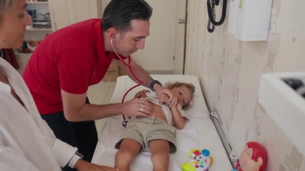 Çocuk Doktoru Çocuğu Muayene Ediyor Erkek Doktor Hastanede Otoskopla Çocukları — Stok video